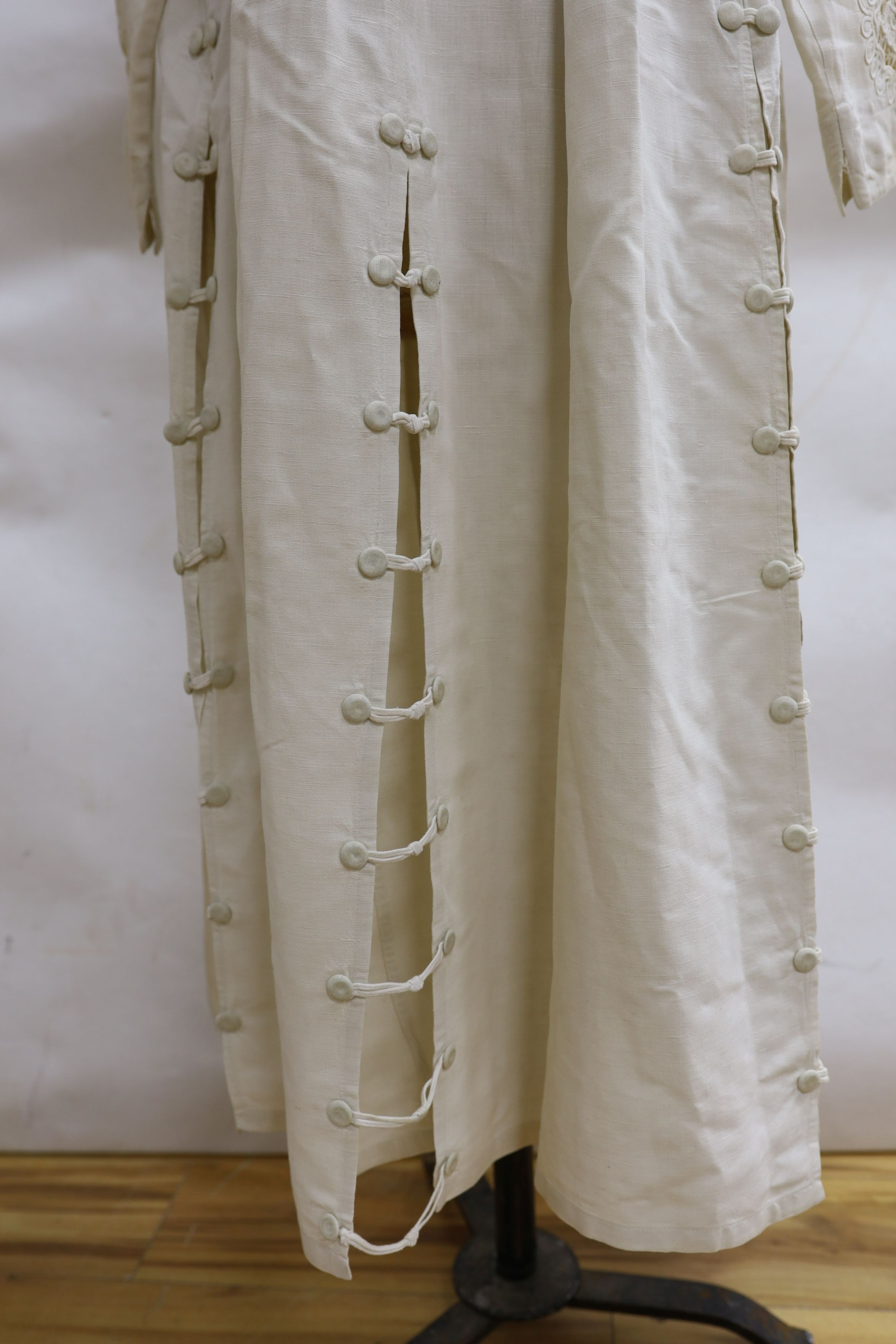 An Edwardian white/cream linen lady's coat with cut work detail and unusual button detail to the back